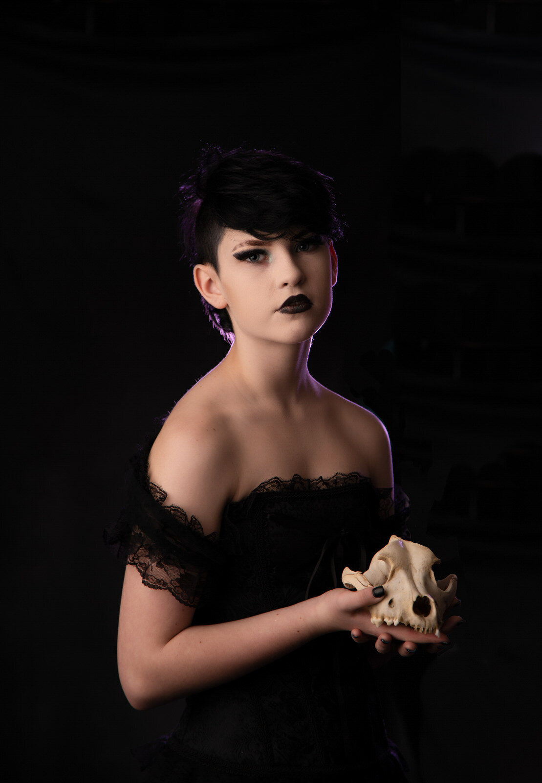 senior-girl-backlit-in-purple-holding-skull