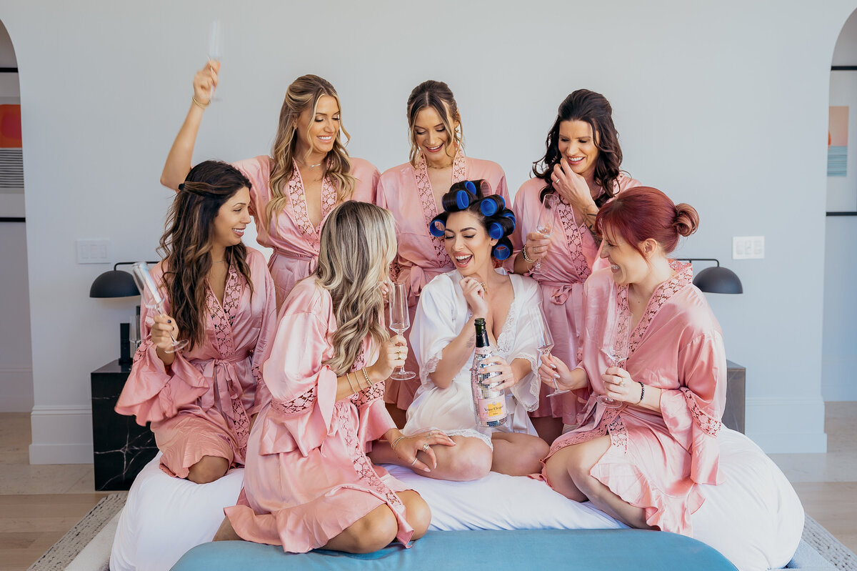 Editorial style bride with her bridemaids in malibu popping champagne breanaisley.com