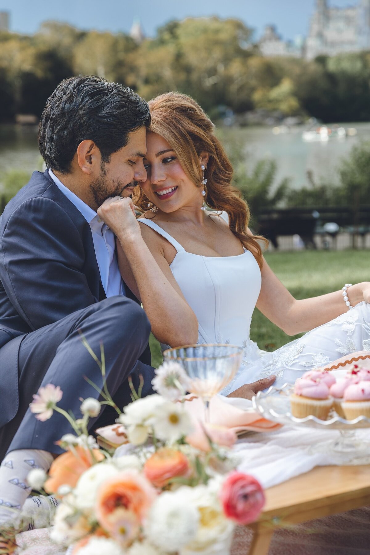 Bride and groom sitting together at romantic picnic setup