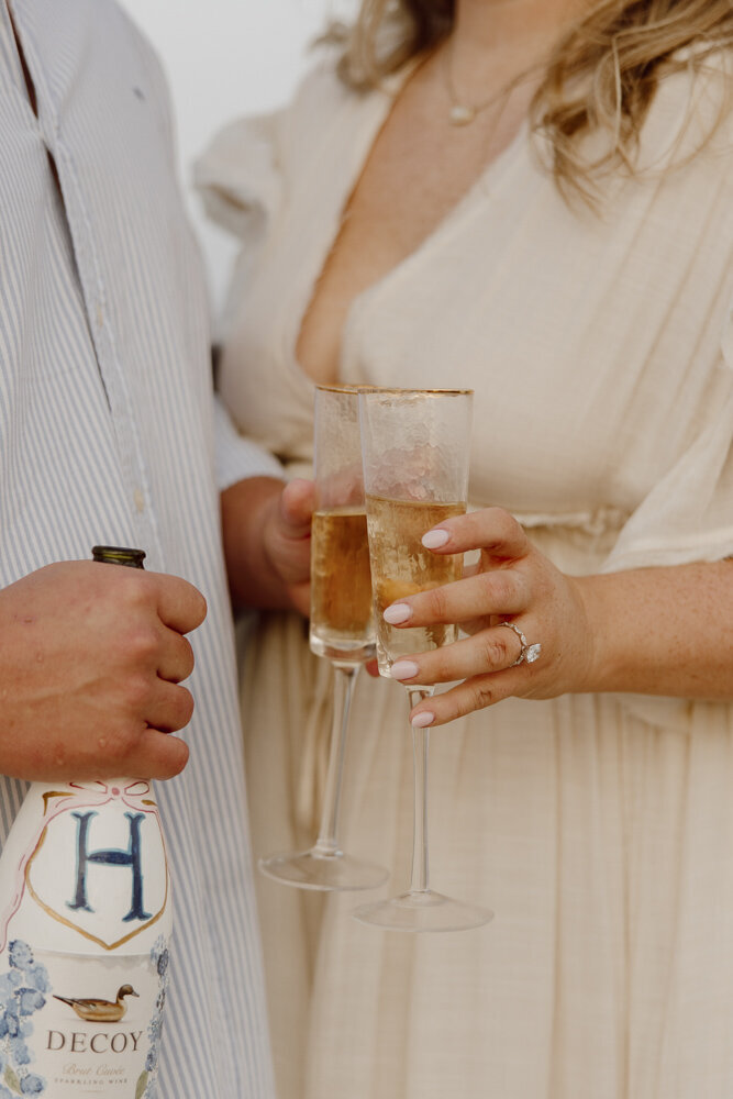 Engagement session with champange glasses and painted champagne bottle.  