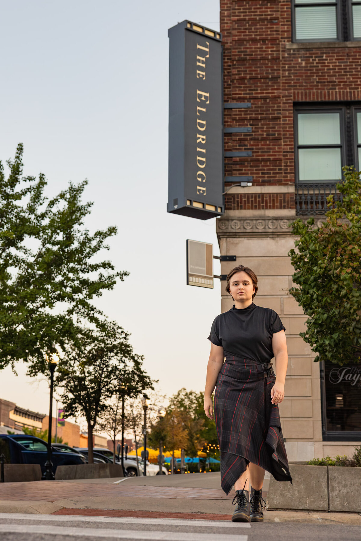 A senior girl walking across a cross walking in downtown Lawrence KS