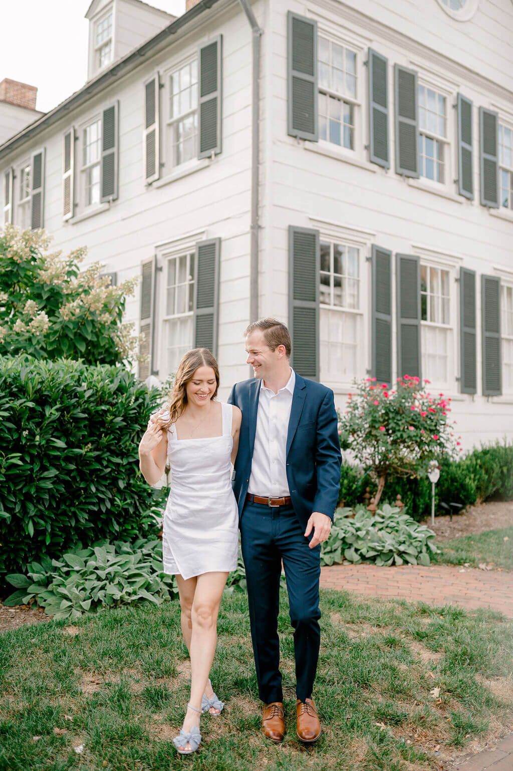 Couple walking and laughing during their engagement photos in Old Town Alexandria