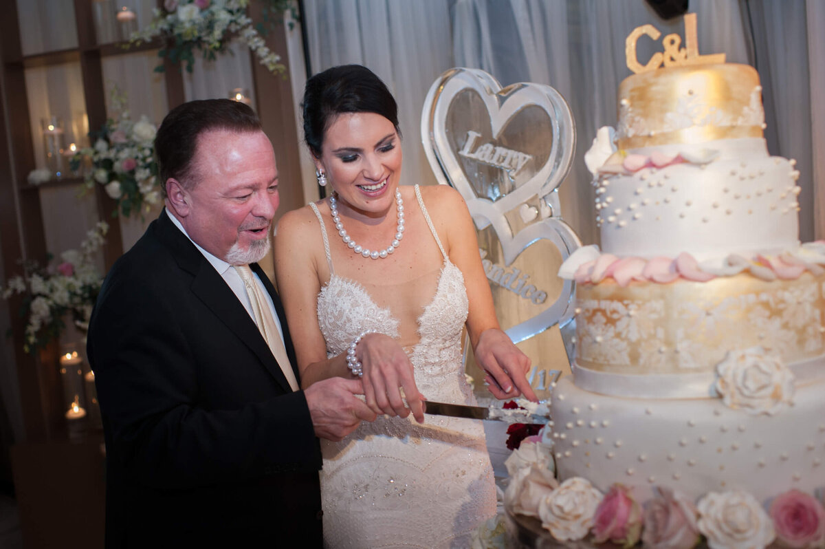 Newly married couple joyfully cut their big and beautiful wedding cake