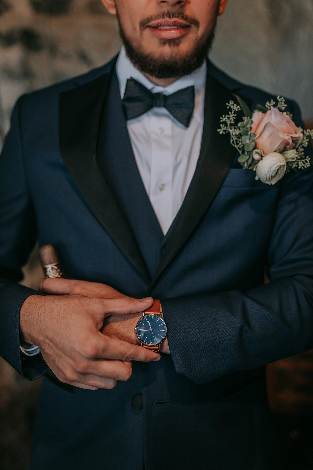 Grooms attire while holding his watch