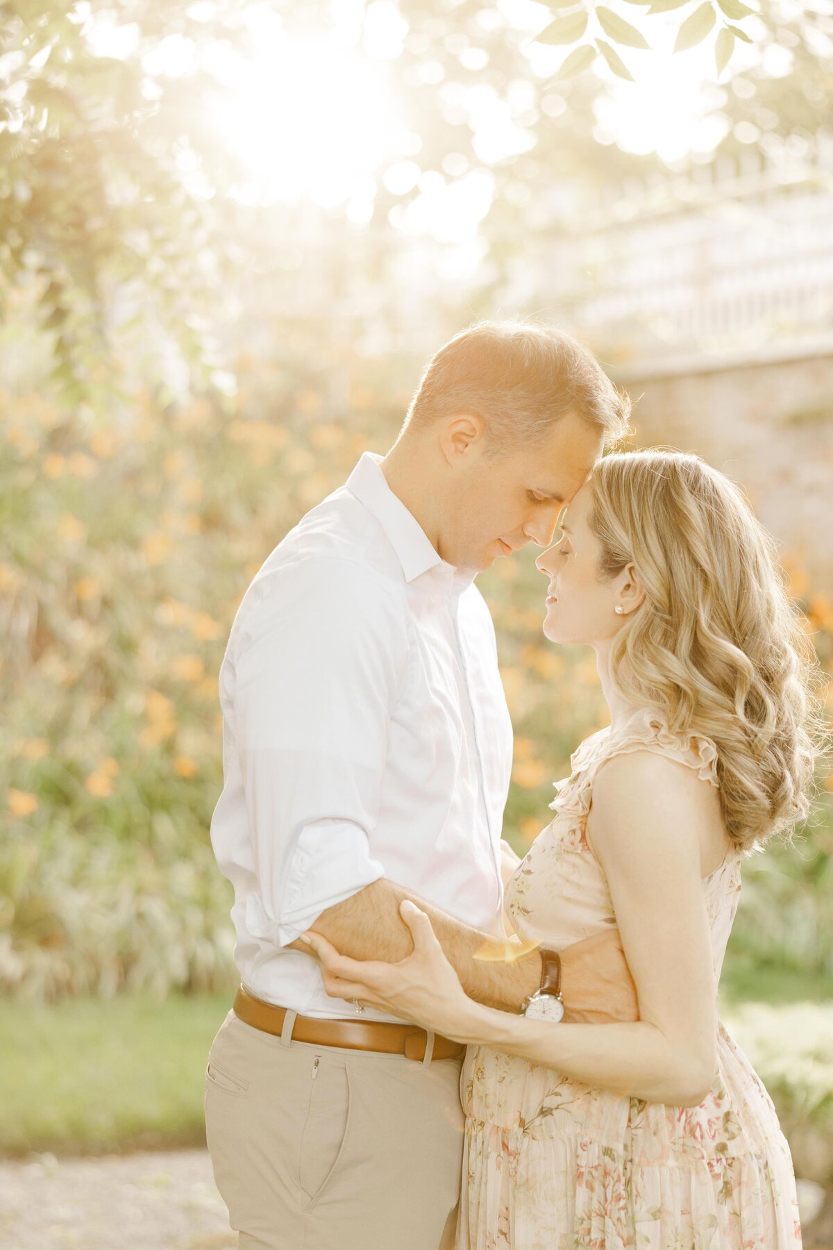 Golden light falling over pregnant couple embracing by Northern Virginia Maternity Photographer