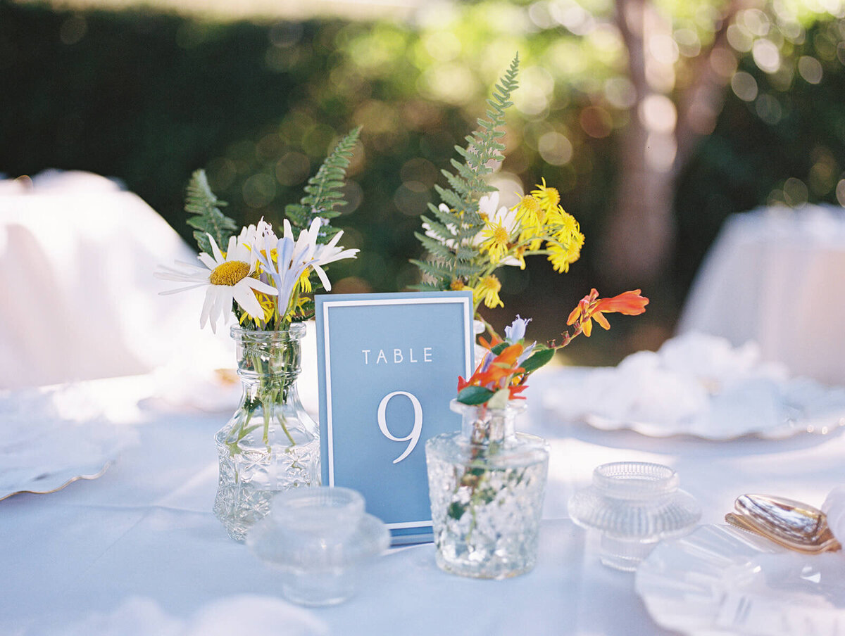 Close up of a table setting with flowers and a table 9 sign.