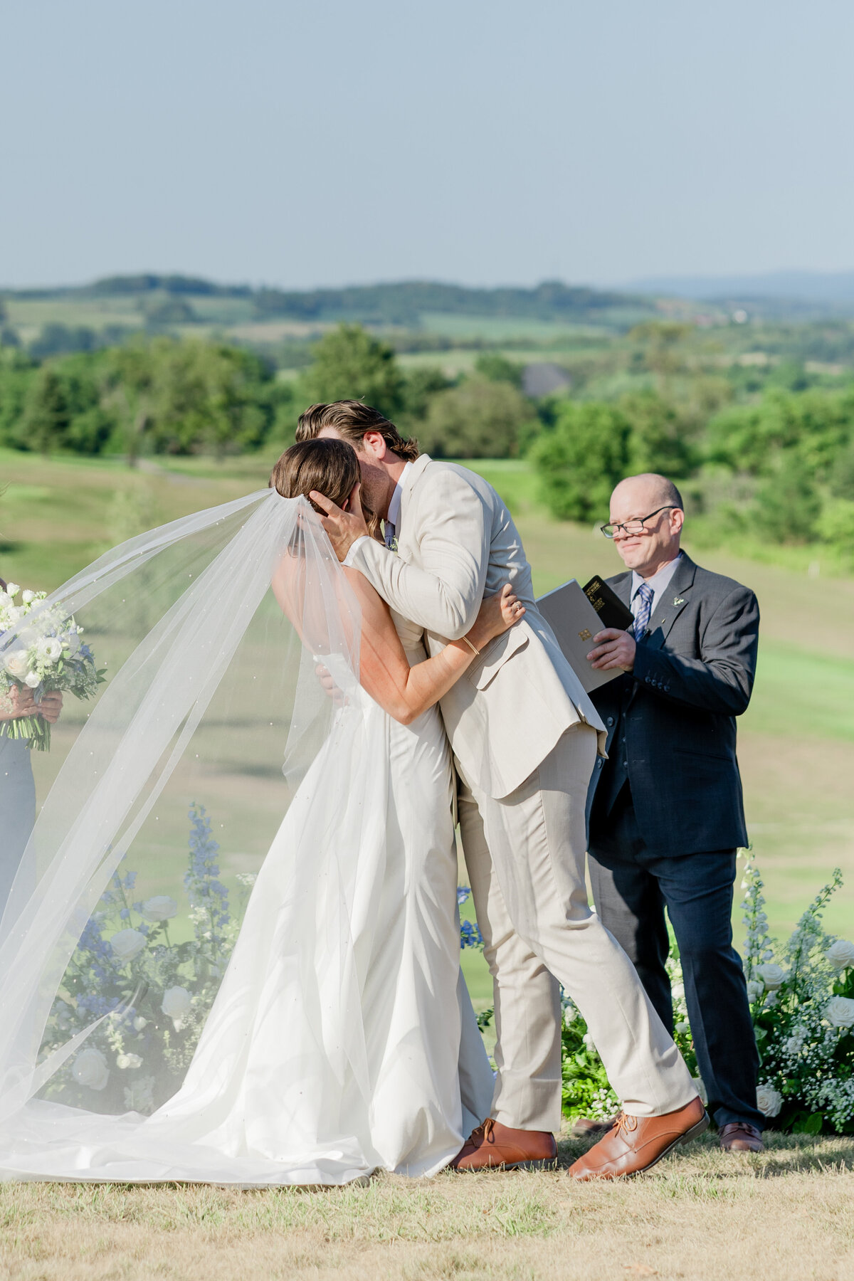 Couple kissing after the wedding officiant pronounced "you may kiss the bride"