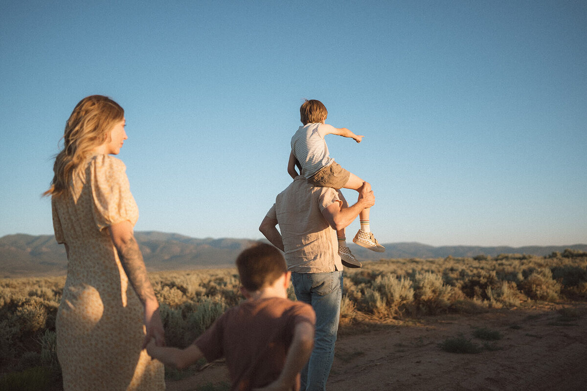 family of four walking in new mexico desert in taos