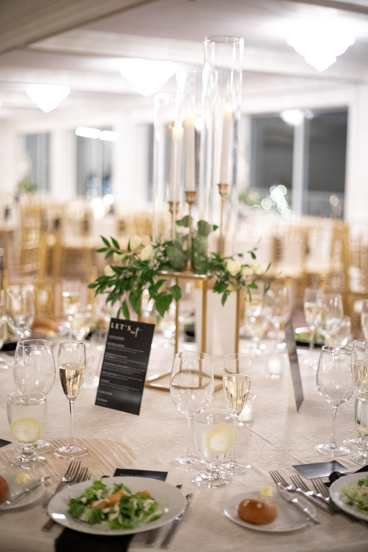 Classic wedding tablescape with gold vases and white tablecloths