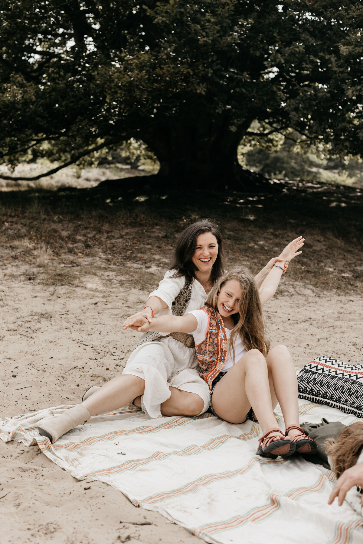 Moeder en dochter op picknickkleed tijdens een gezellige gezinsshoot in Drenthe