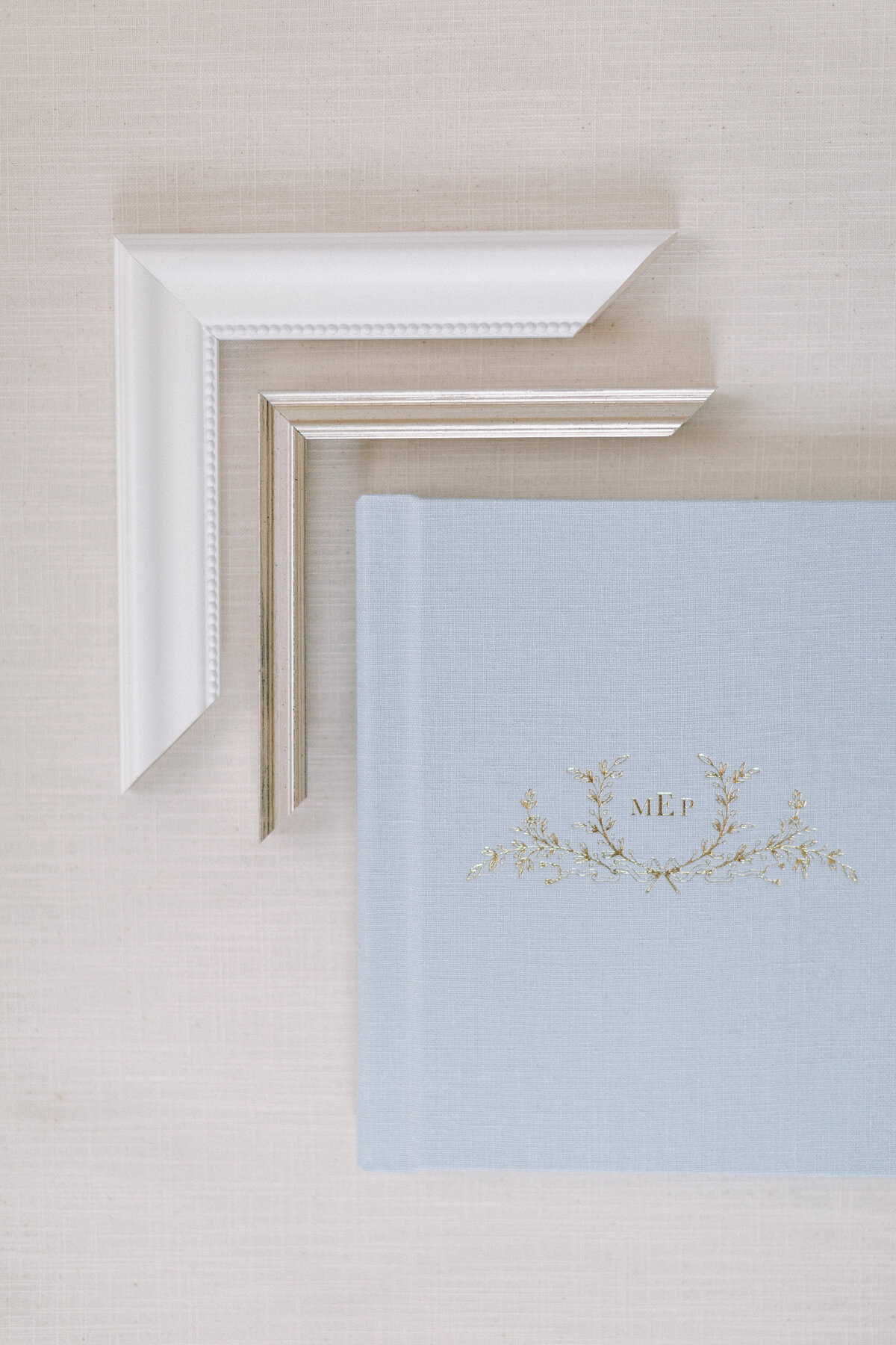 A white and gold frame corner along with a light blue photo album