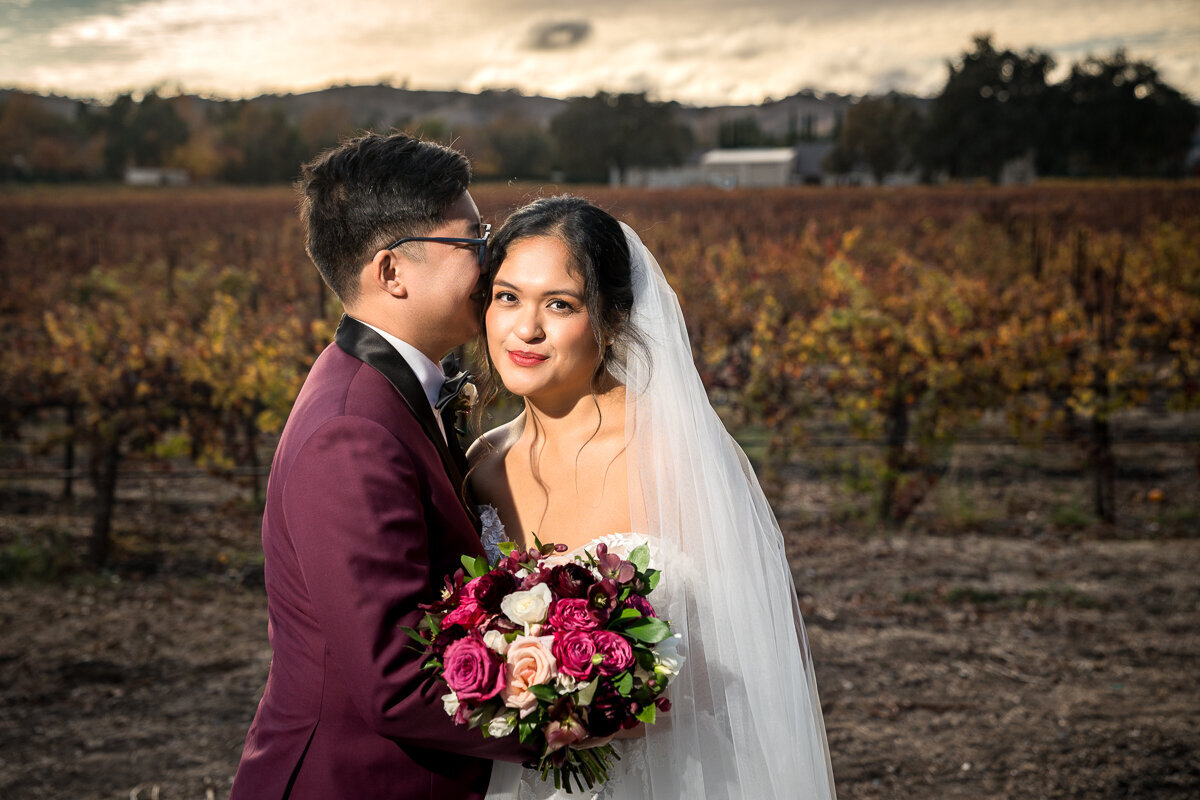 A romantic shot of the newlyweds against a vibrant sunset at in the lush vineyards of Casa Real in Pleasanton. Ideal for outdoor wedding inspiration.