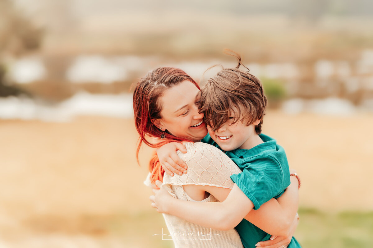 Mama en zoon knuffelen en houden elkaar stevig vast bij de Drunense Duinen