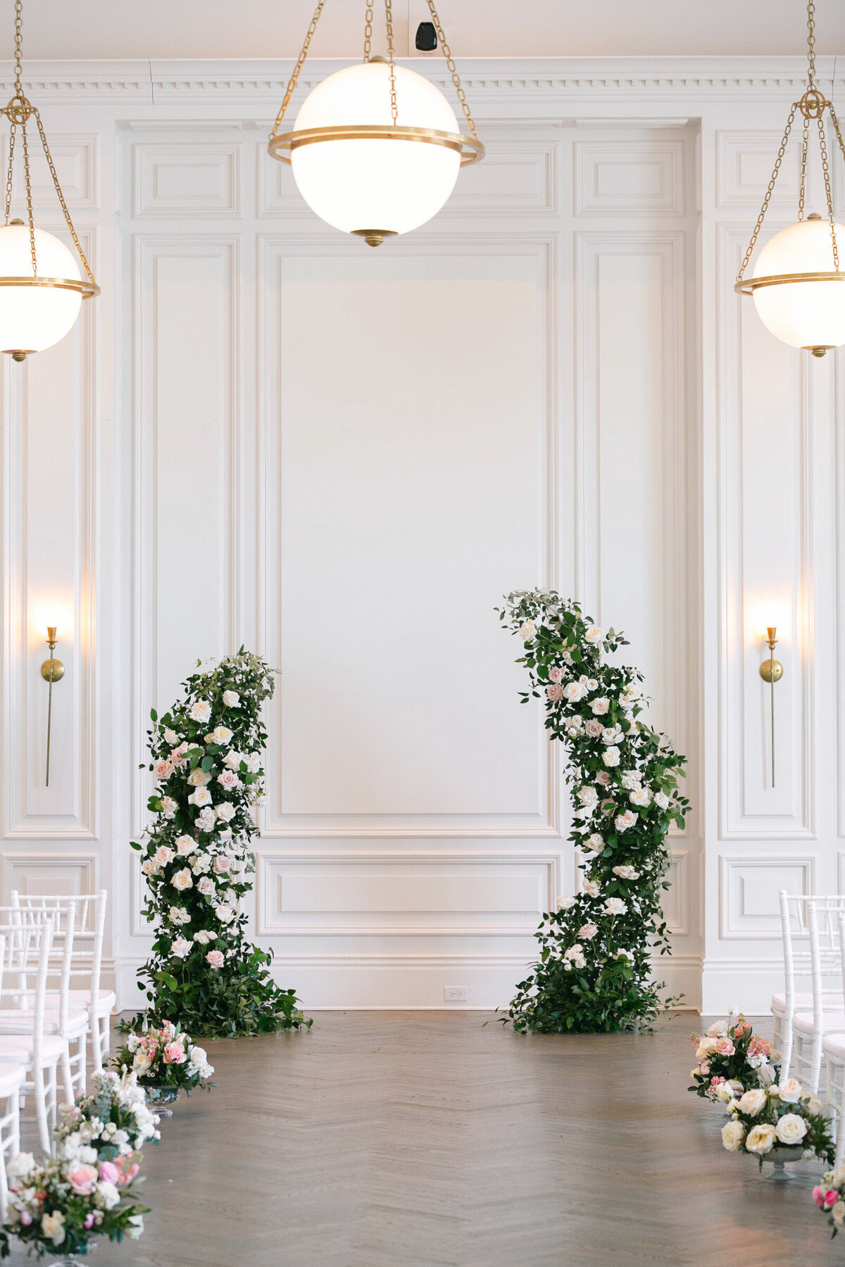 empty Governor’s Room at The Adolphus in Dallas set up for a wedding ceremony, featuring a floral arch and floral arrangements along the aisle, highlighting the elegant venue décor.