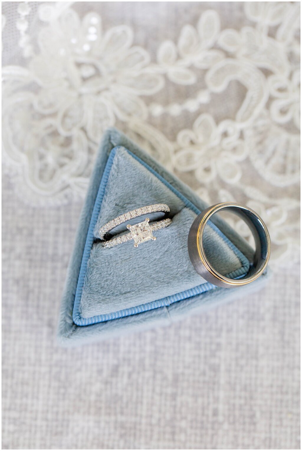 engagements rings in blue triangle ring box laying on veil