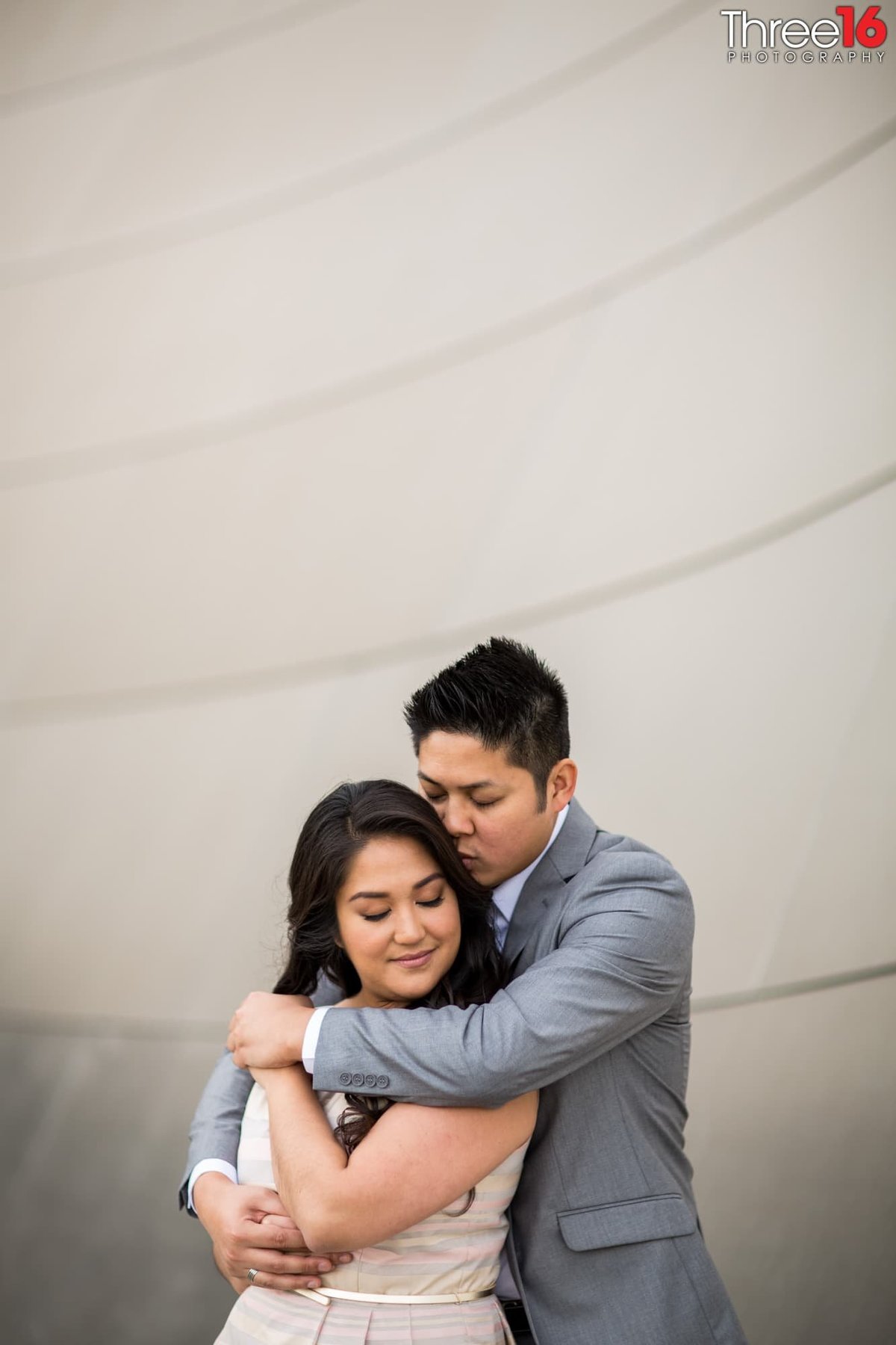 Groom to be embraces his Bride from behind during engagement session