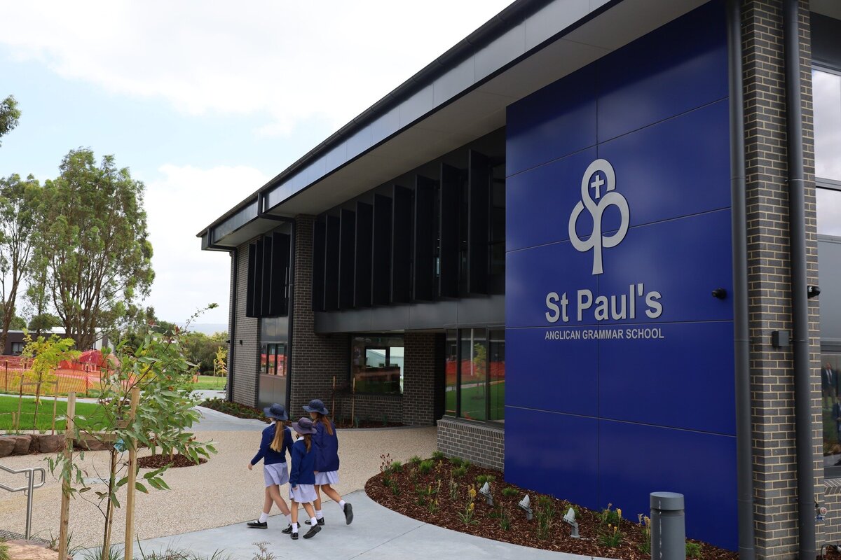 Exterior of St Paul’s Anglican School showing modern architecture with students walking near the main entrance.