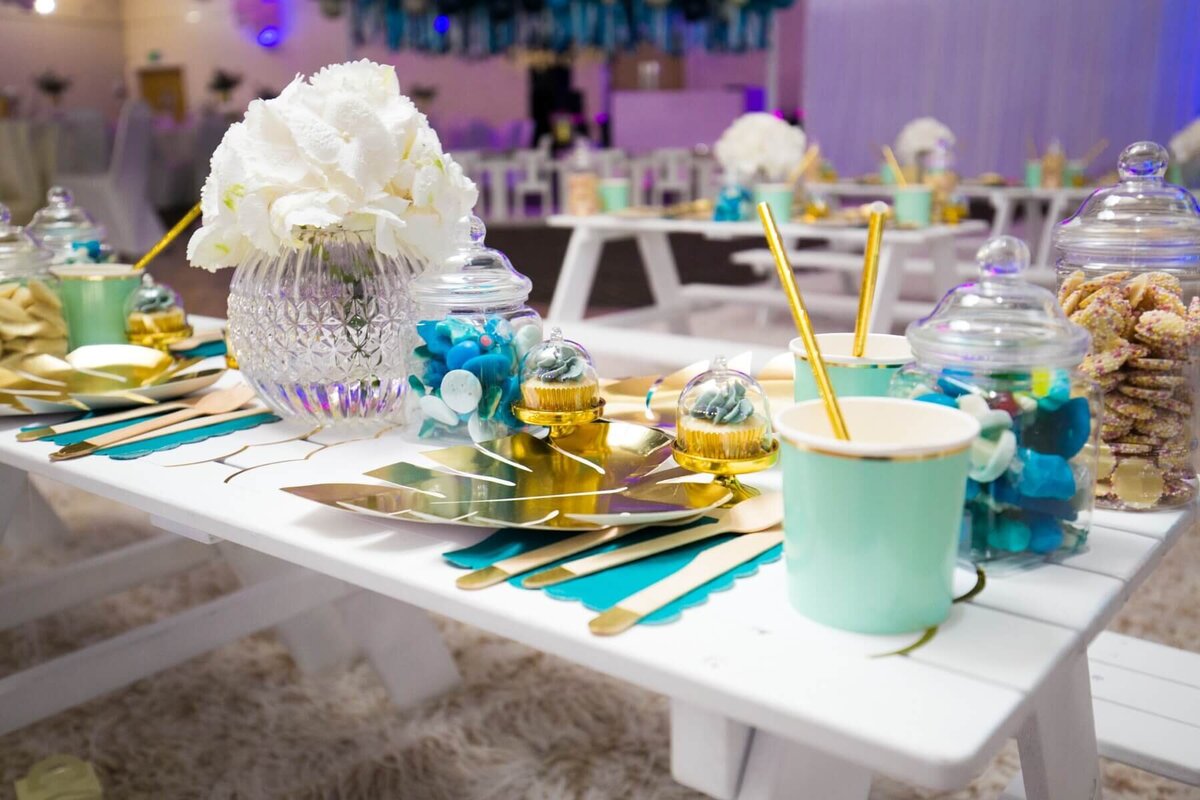 Party table decoration with turquoise cups and white flowers