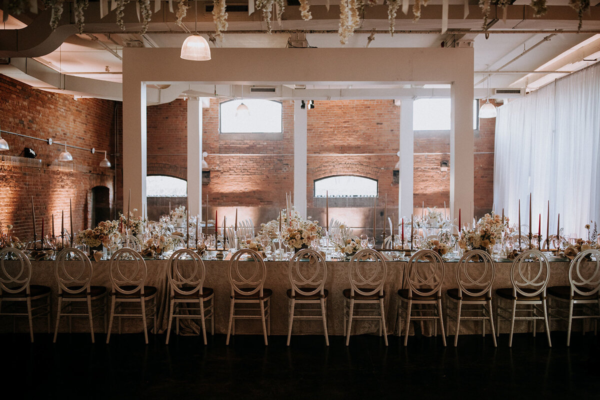 A wedding reception at Entrepot Dominion featuring lush floral centrepieces and industrial chic decor.
