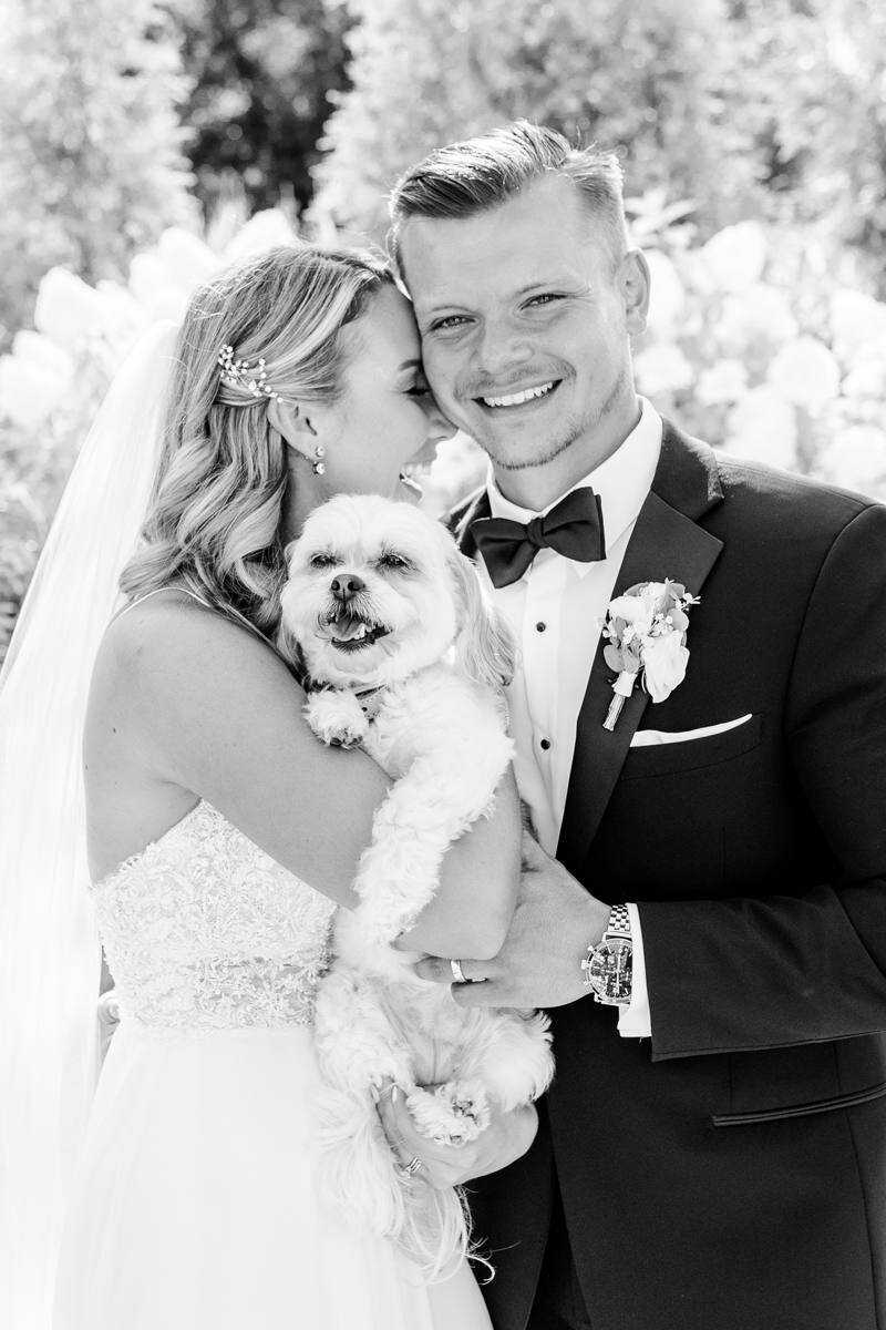 black and white photo of bride and groom with their dog
