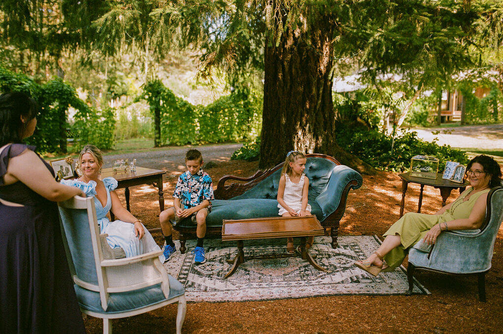 People seated outdoors on decorative chairs rented from Birdie June Events.