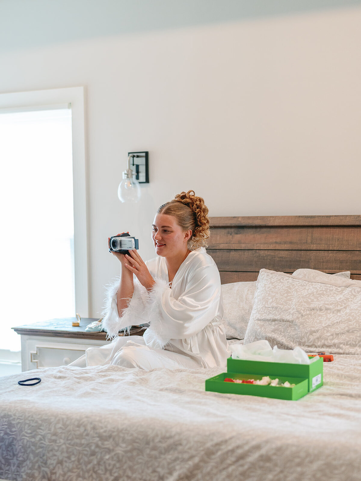 Bride with a camcorder recording her getting ready