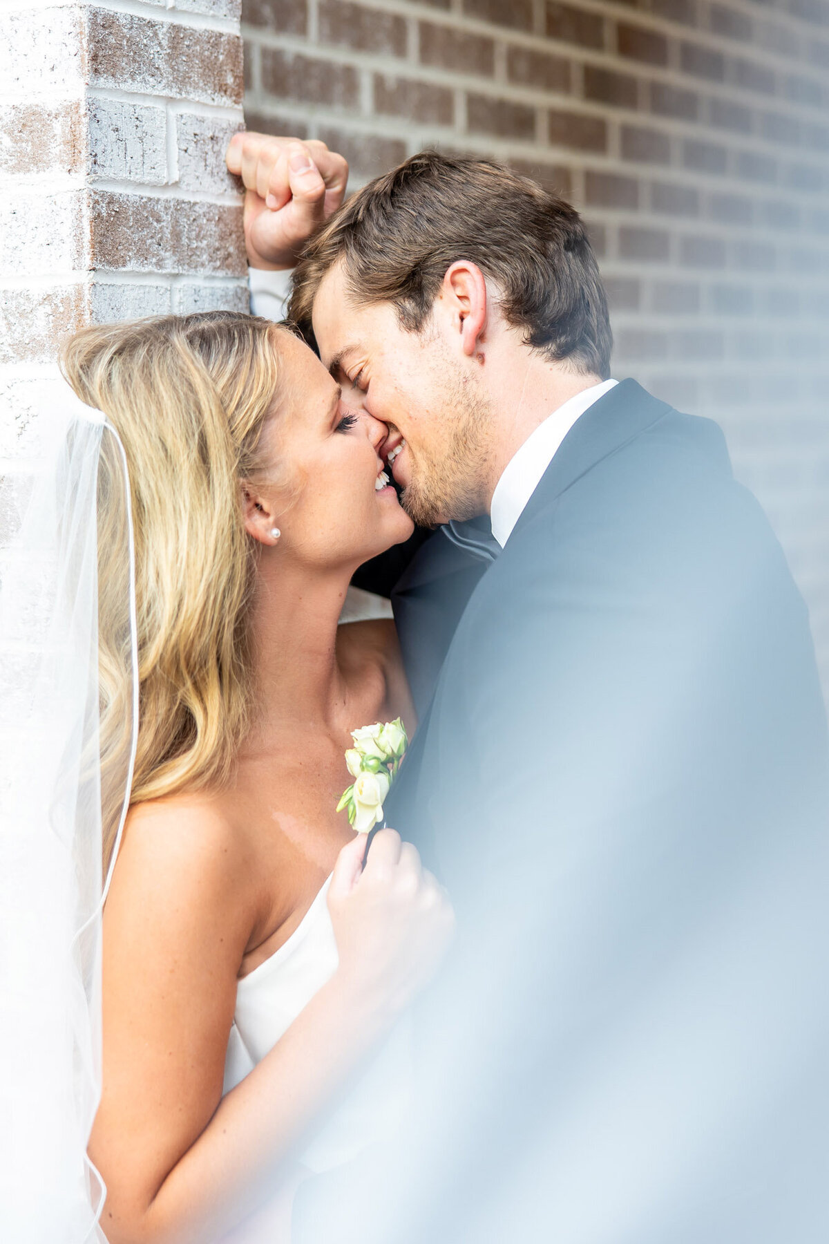Groom playfully kissing his bride