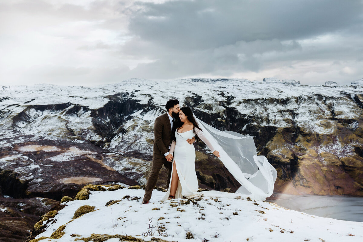 Joyous elopement captured as a couple kisses atop Iceland's Snæfellsjökull volcano, their love as fiery as the landscape.