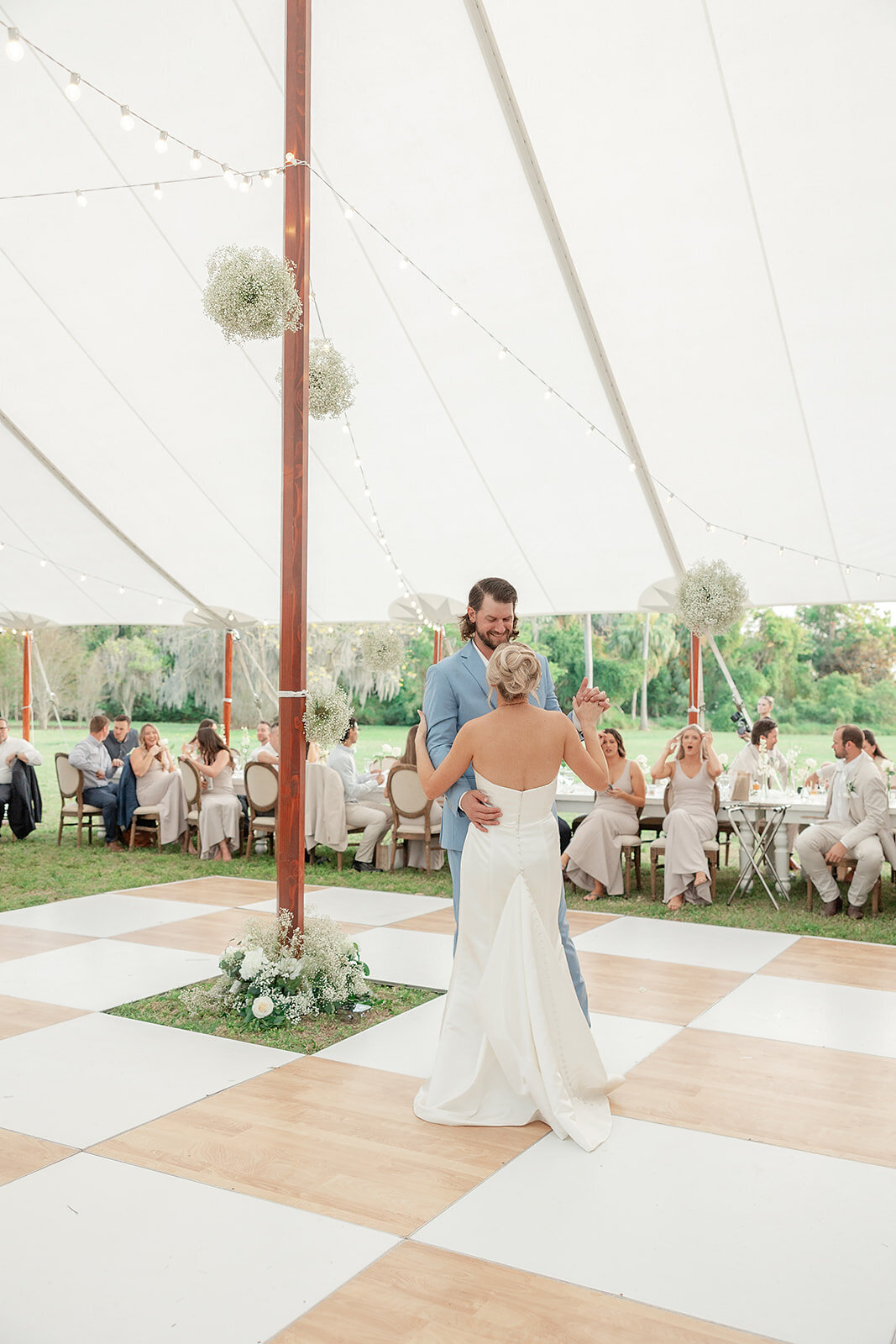 Bride and Groom doing their first dance on tan and white checkerboard dance floor