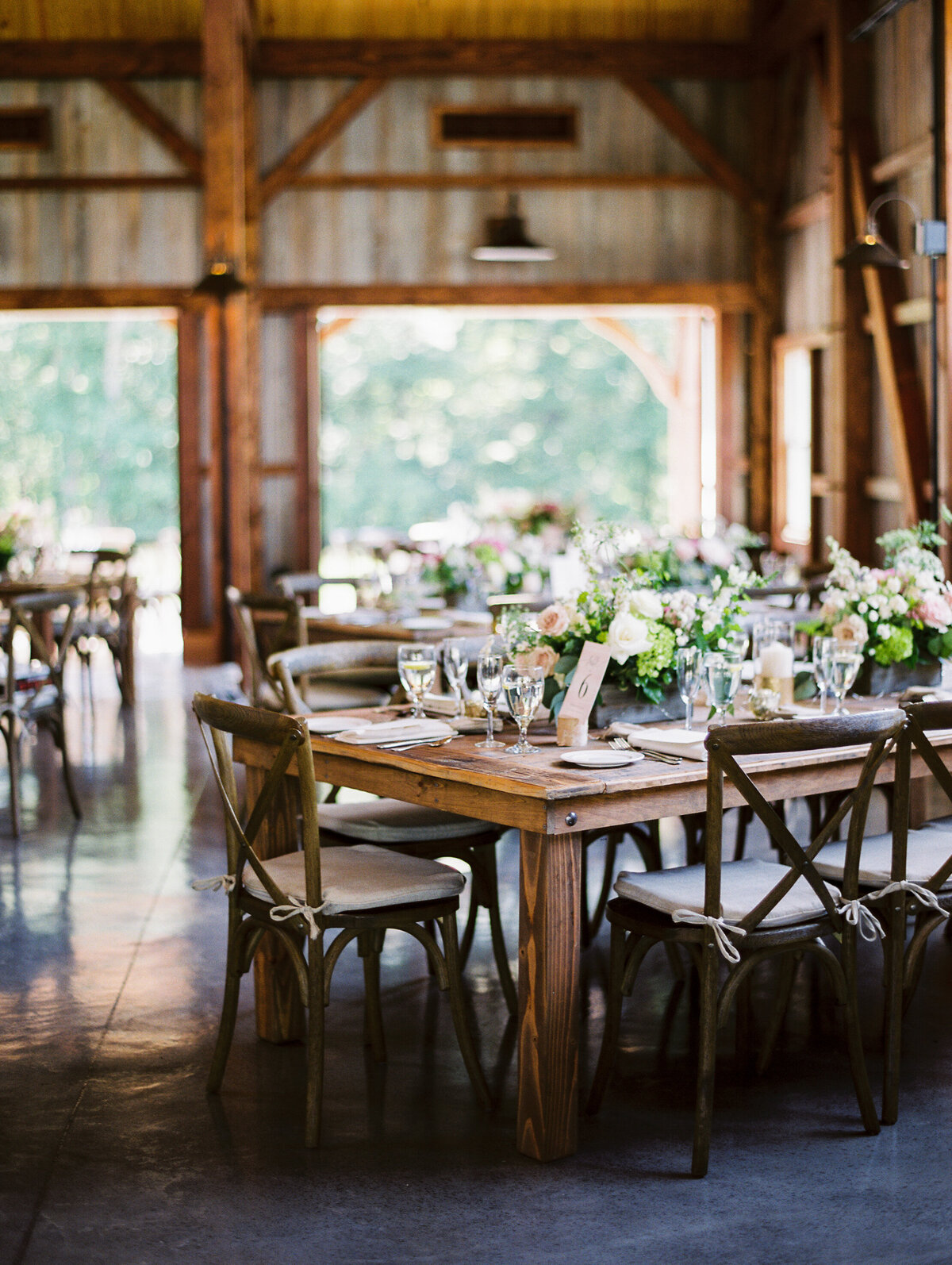Wooden tables and chairs decorated with floral centerpieces