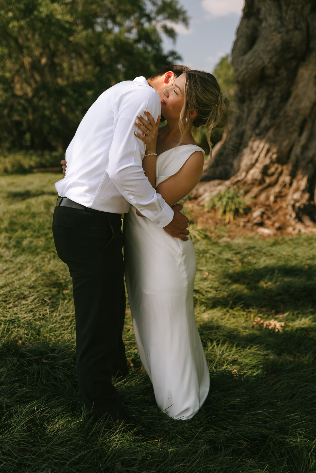 Wedding couple taking their Louisiana engagement photos at Rip Van Winkle Gardens in Jefferson Island surrounded by wildflowers and moss draped trees. 