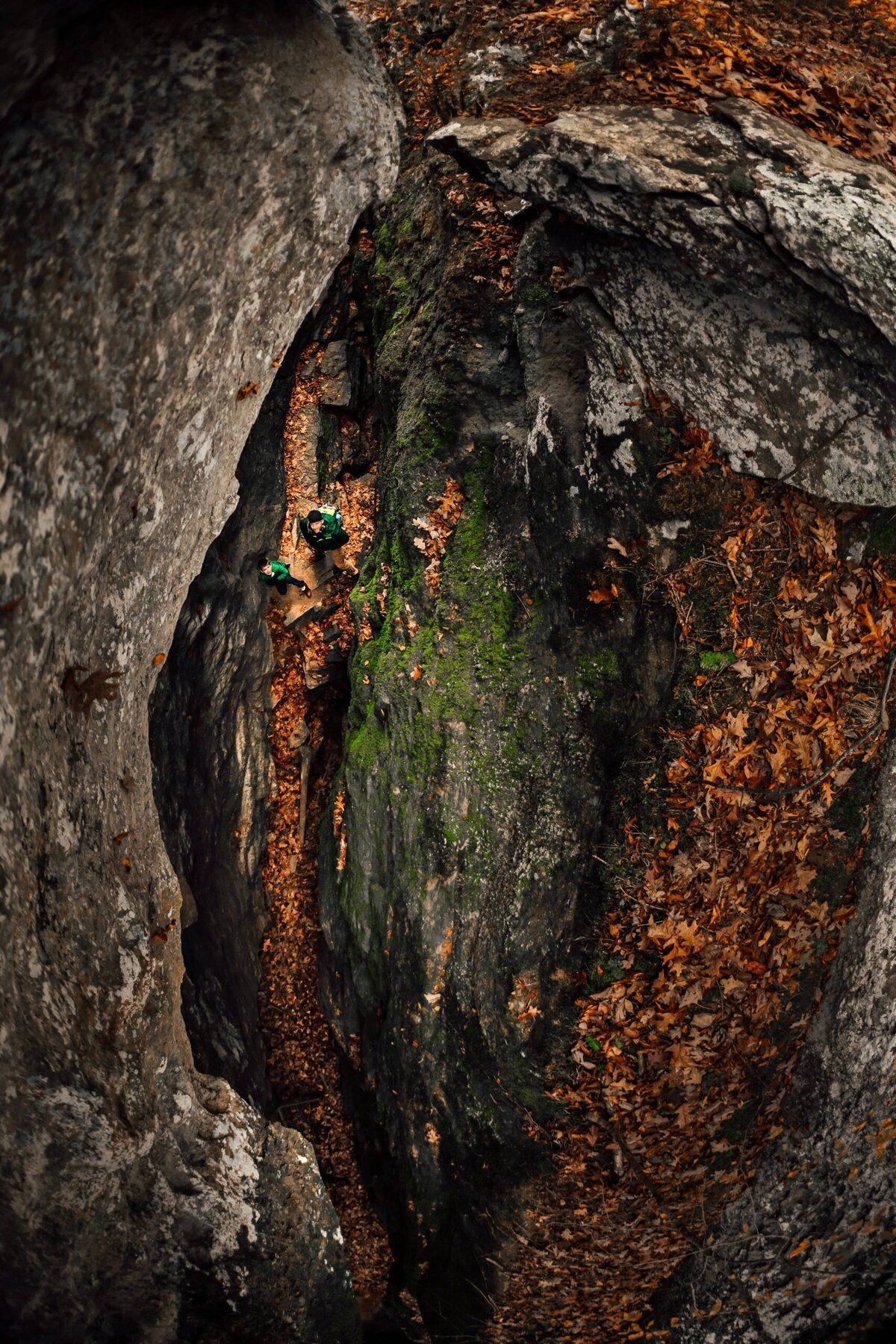 A view from above of a father and son hiking through a rocky ravine.