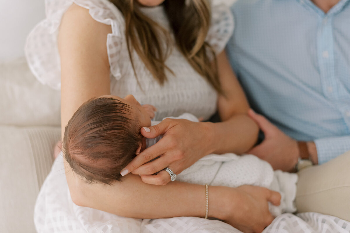 close up of newborn's head with mother holding him in a lifestyle family portrait session