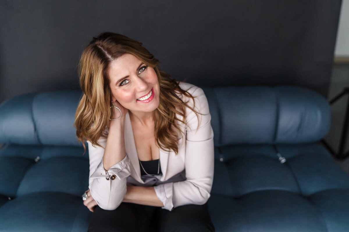 Woman leaning on armrest smiling during personal branding photoshoot