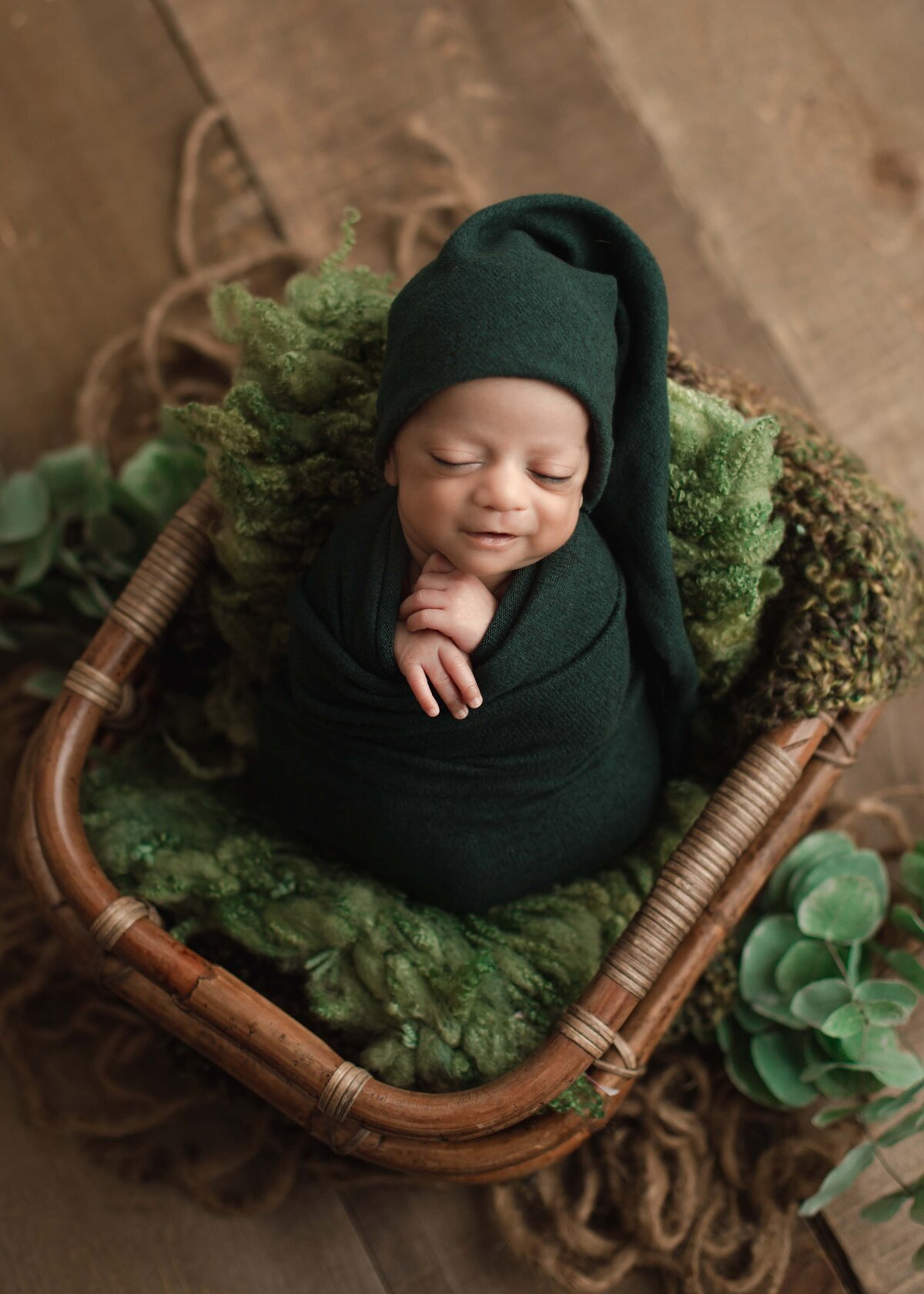 Baby boy wrapped in green in a basket