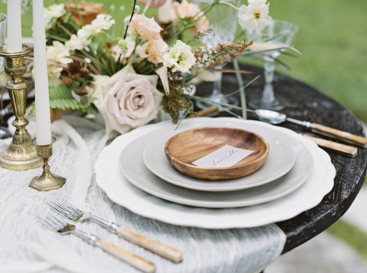 A wooden bowl plate stands on a stack of plates that would make eating impossible. Great shot tho./