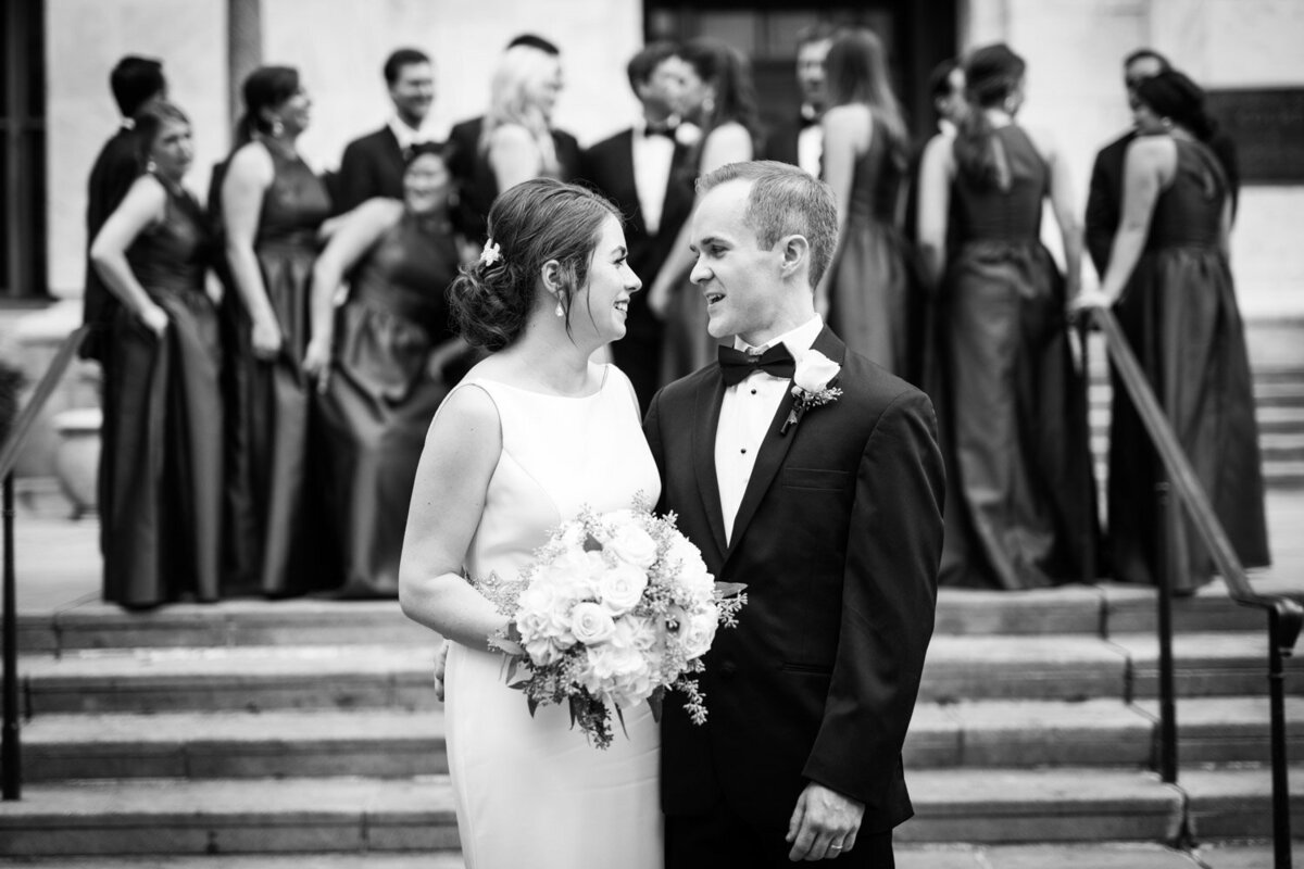 Bride and groom with wedding party in the background