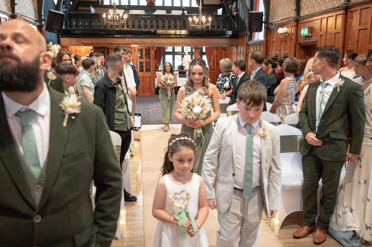 Flower girl, paige boys and bridesmaid's walking down the aisle at worsley court house 