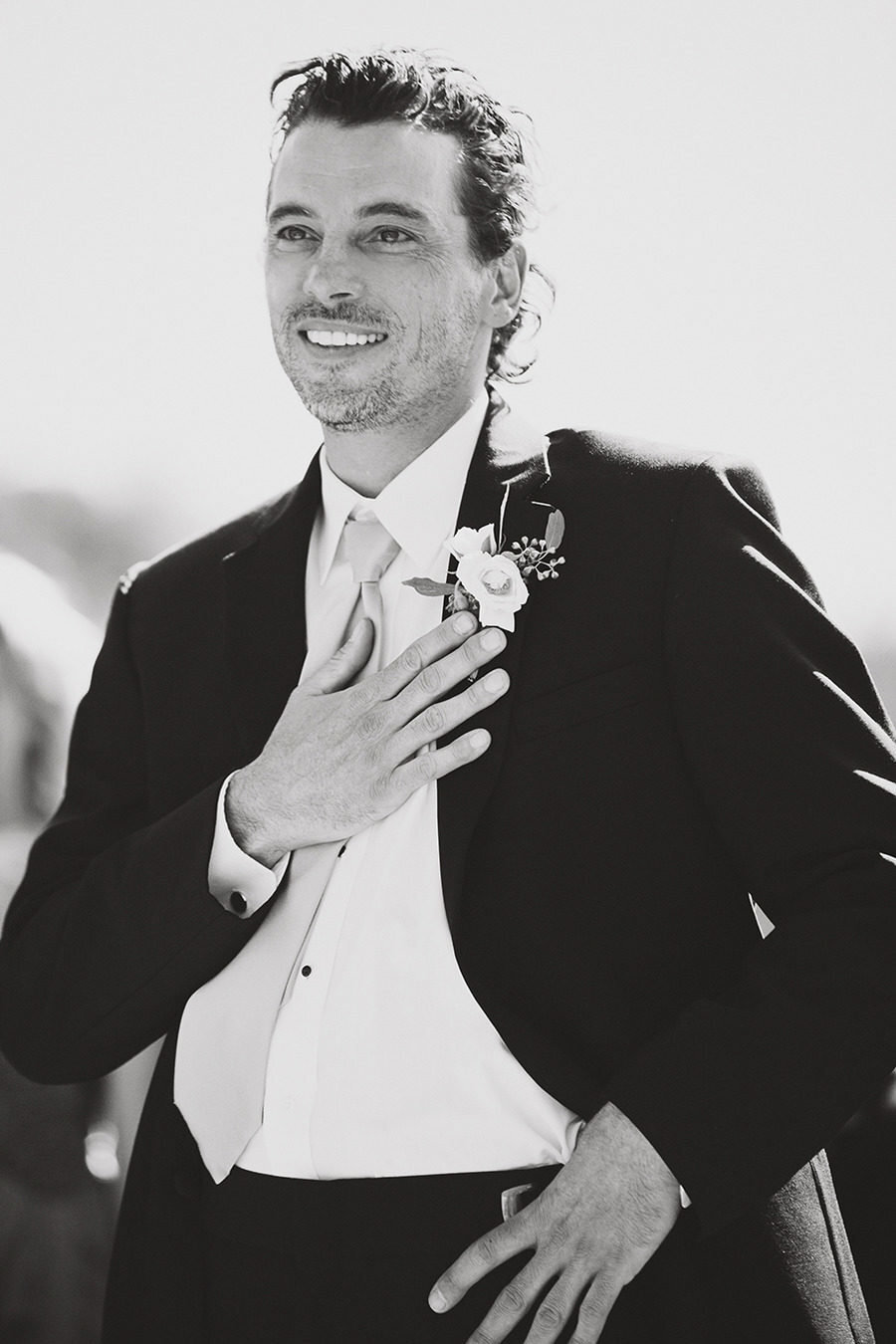 groom with hand over his heart