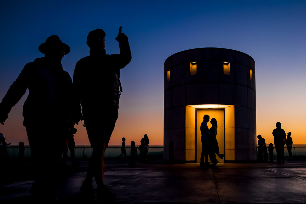 A group of sightseers pass by as a bride and groom to be are photographed during sunset at Griffith Park, photo by Tanya Parada