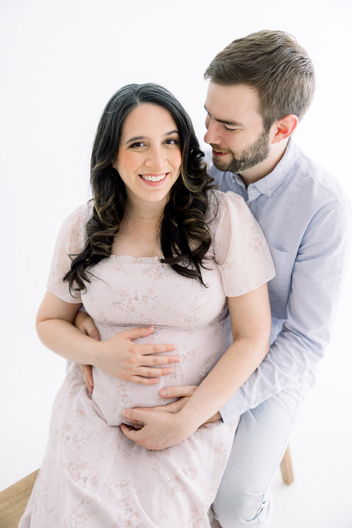 Husband and pregnant wife cuddling for Tampa maternity photographer Tina Marie Studio.