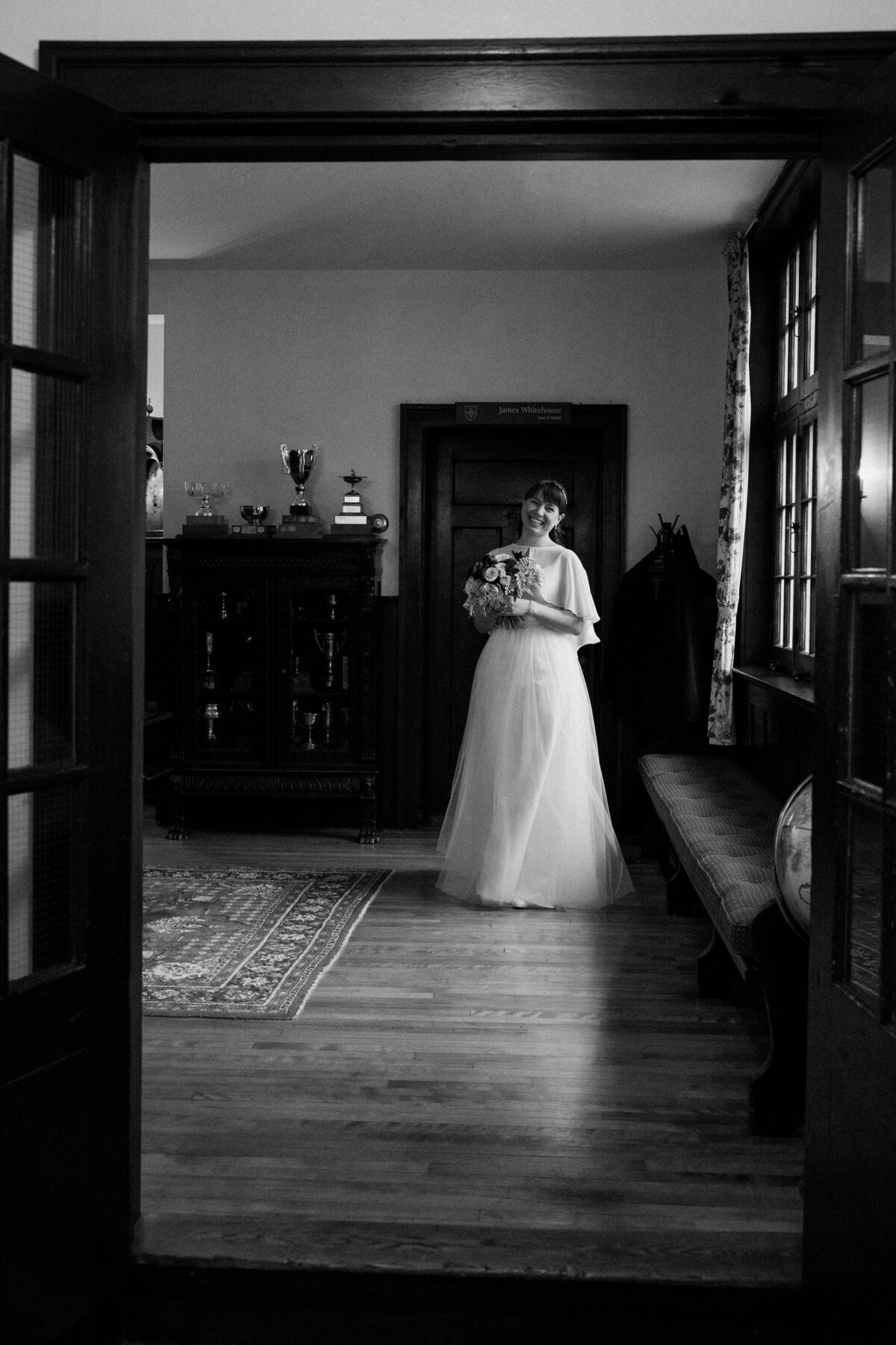A long shot of the bride smiling in her wedding attire