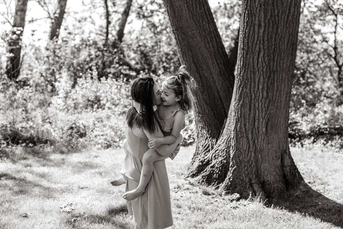 Mom kissing daughter during family session in Wheaton, IL