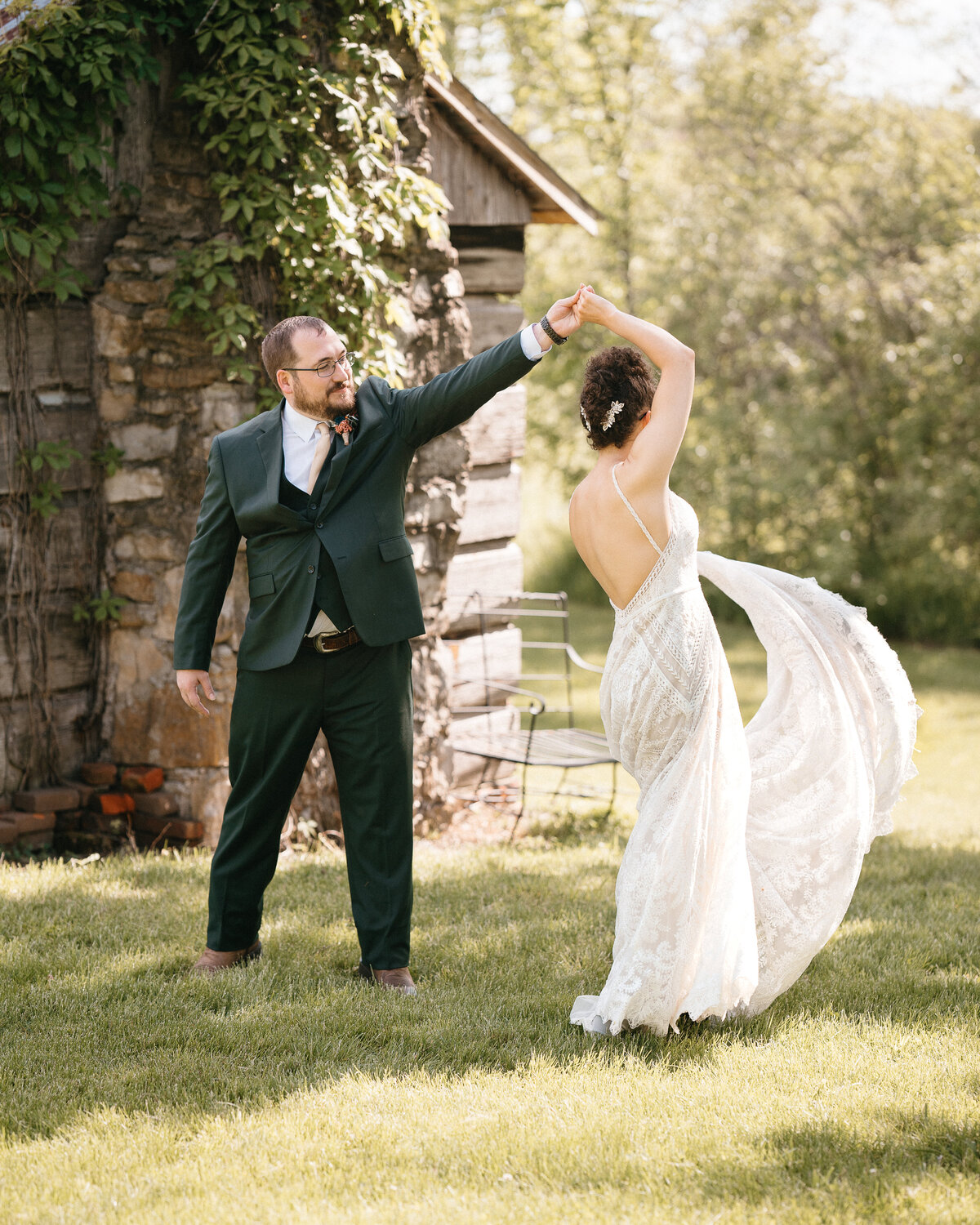 Groom twirls bride while her wedding gown flows out