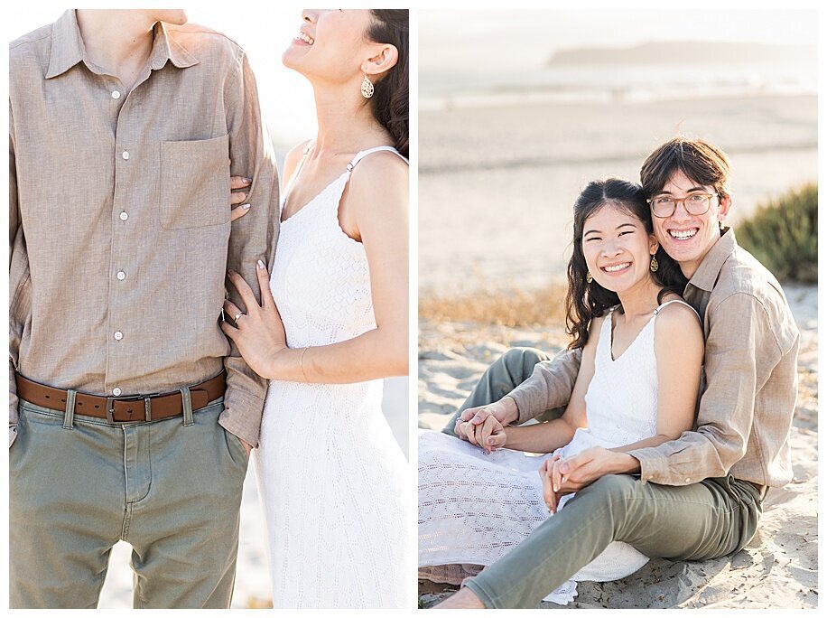 engaged couple sitting in sand smiling