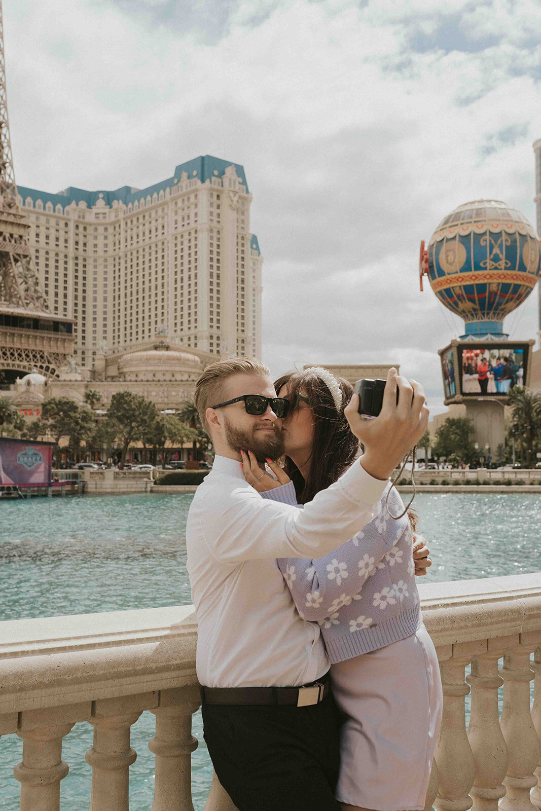 Person in a purple dress kissing partner on cheek in downtown Las Vegas