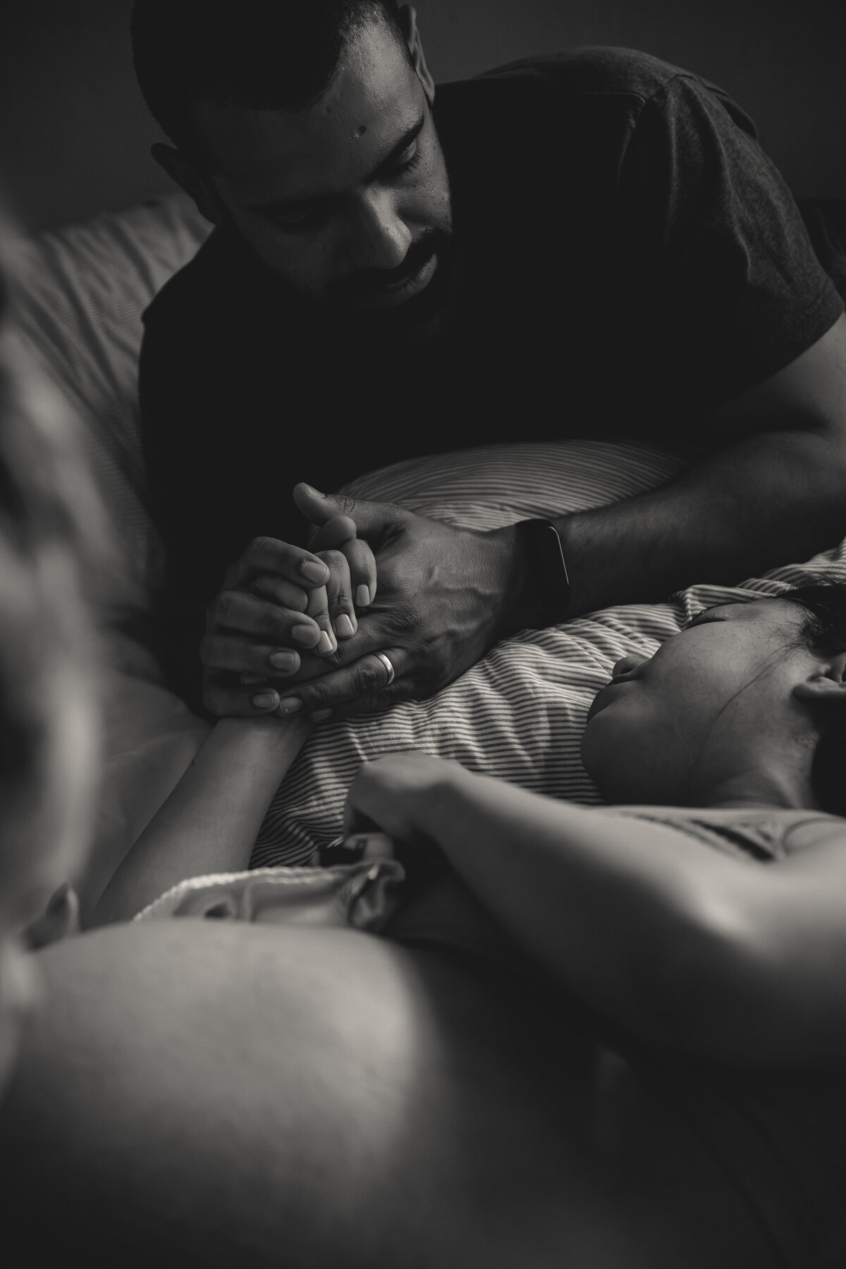 Husband supports wife during contraction by holding her hand