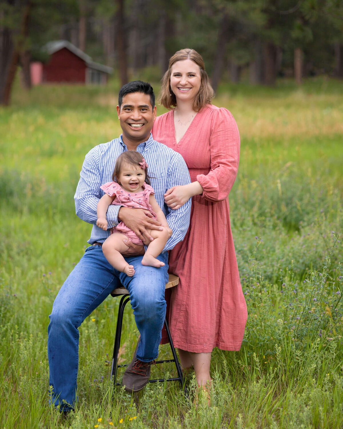 young family standing togerther in a field in Beulah Colorado