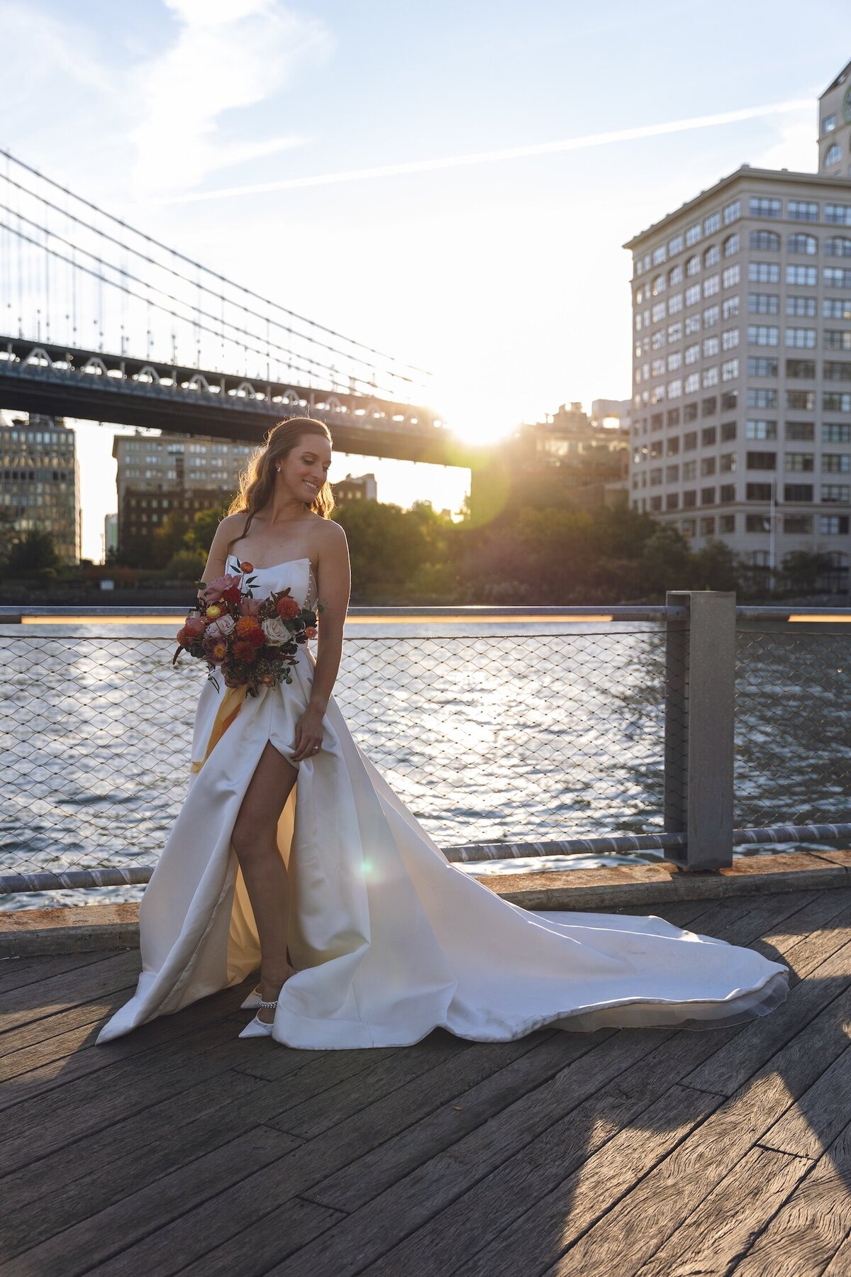 Bride walking along Brooklyn waterfront in satin gown