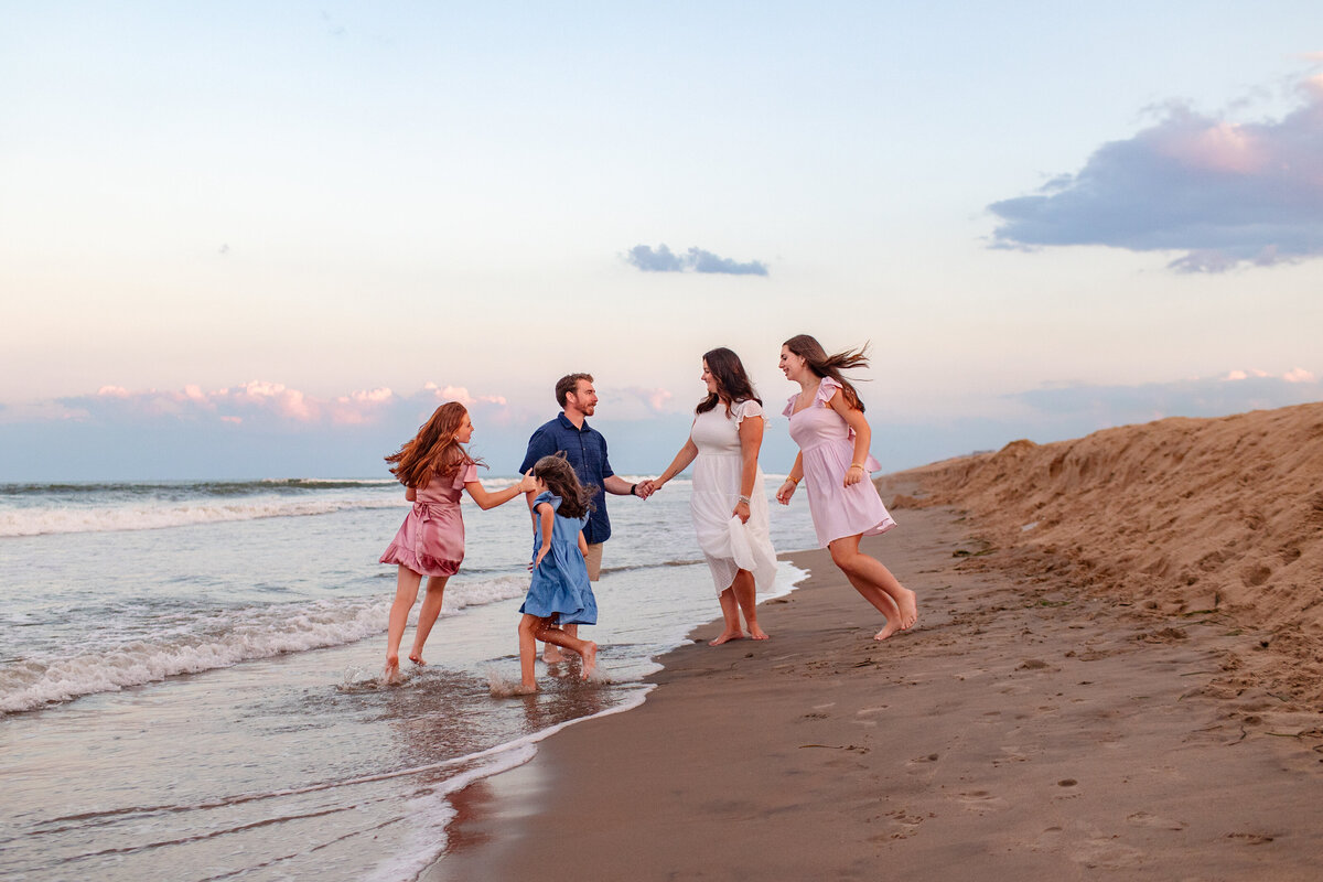 Blended family playing together in the ocean during a candid Virginia Beach session with Brooke Tucker Photography